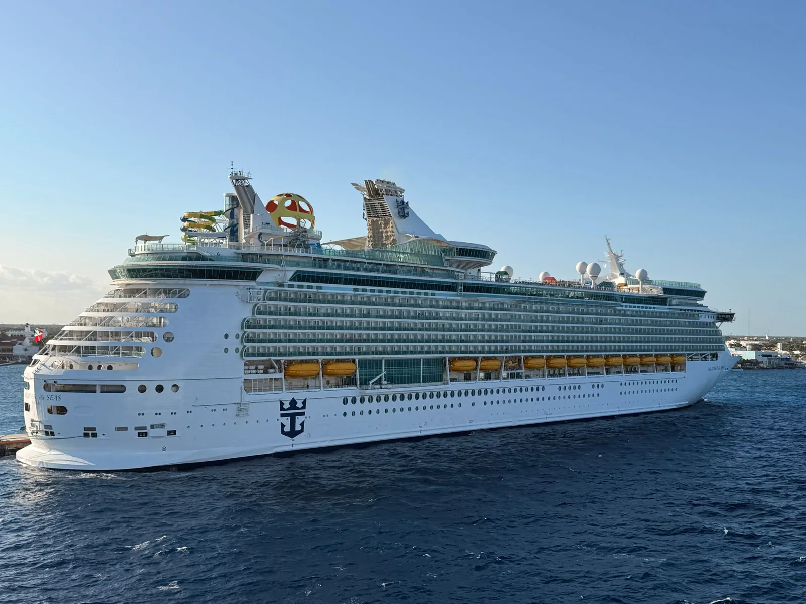 Cruise ship docked at a sunny Caribbean port with turquoise water