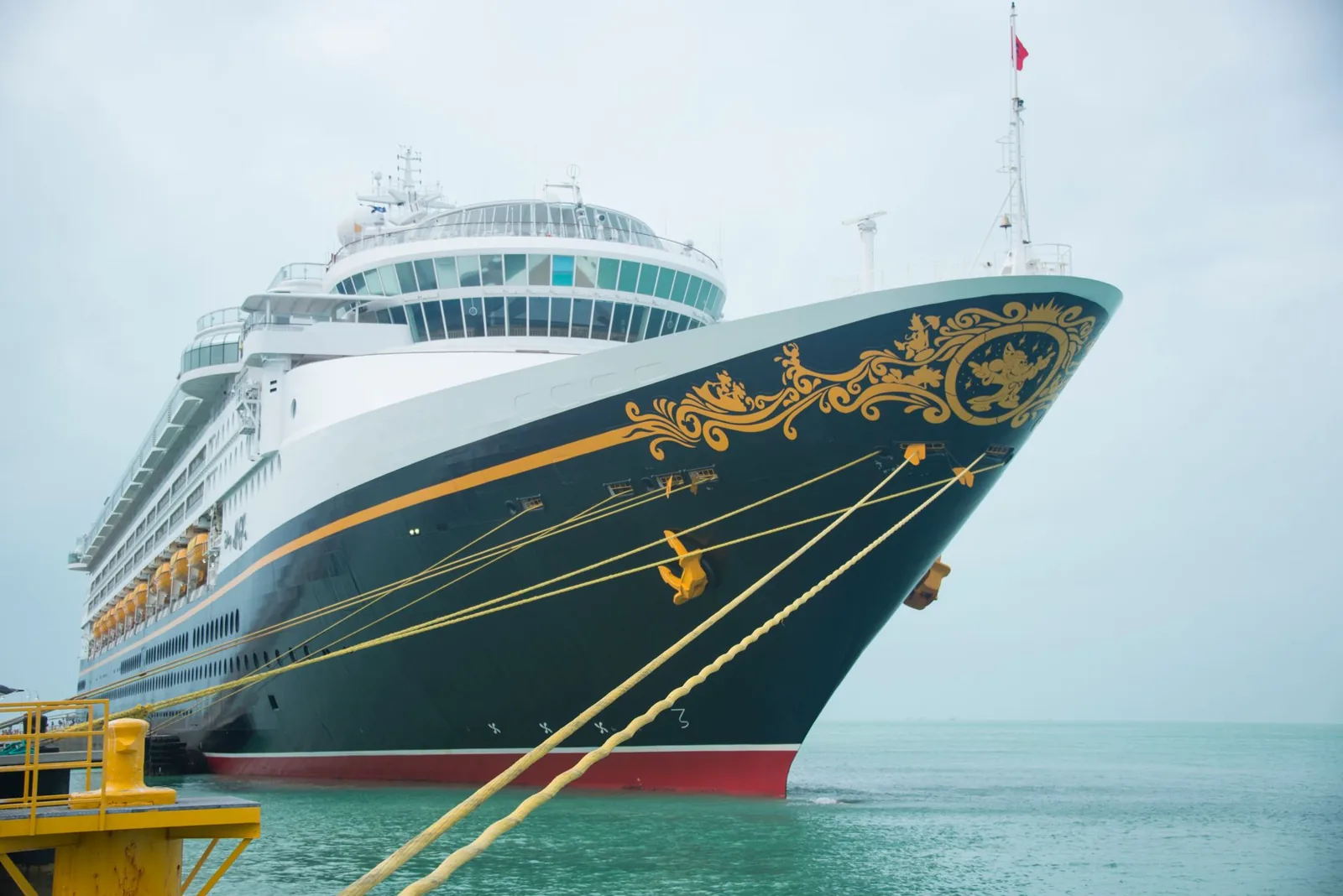 Disney cruise ship docked in port at sunset